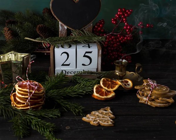 Drewniany kalendarz z datą 25 grudnia, ciasteczka świąteczne i wystrój, niski obraz klucza, widok zbliżenie — Zdjęcie stockowe