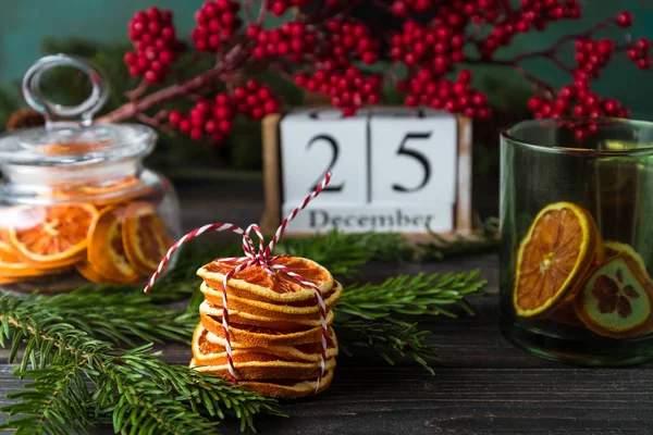 Calendario de madera con fecha 25 de diciembre, decoración navideña, chips de naranja sobre fondo de madera — Foto de Stock