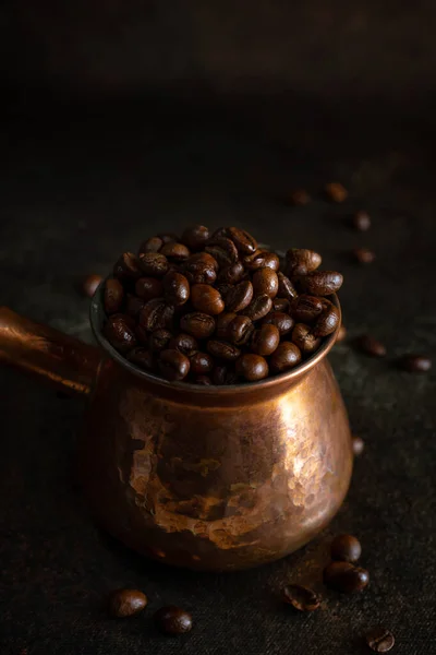Kupfer jezve mit Kopi Luwak Kaffeebohnen auf dunkelbraunem Hintergrund, Nahaufnahme — Stockfoto