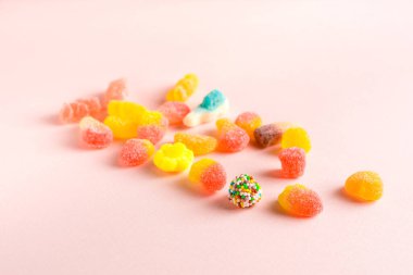 Pembe arka planda çeşitli jelibonlar.