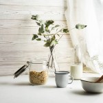 Granola, tasse de lait et fleurs dans un vase sur la table