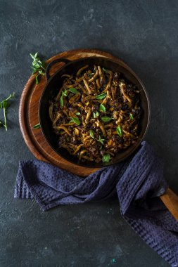 Kızarmış mantar ve tavada otlar.