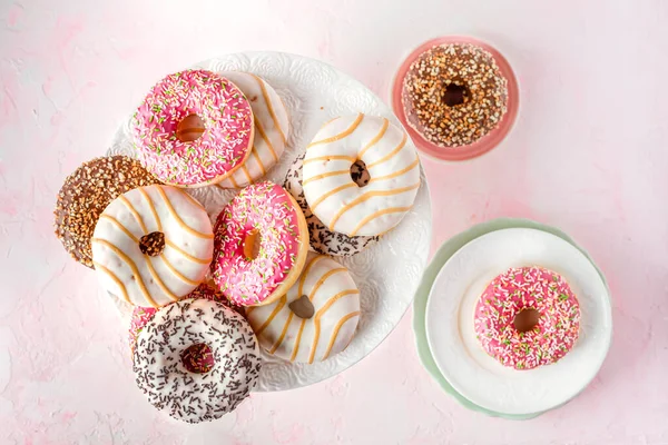 Geassorteerde Geglazuurde Donuts Een Roze Achtergrond — Gratis stockfoto