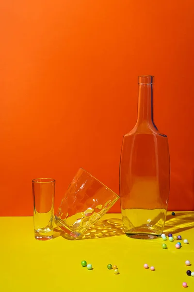Glasögon Och Tom Flaska Ljust Orange Gul Bakgrund — Stockfoto