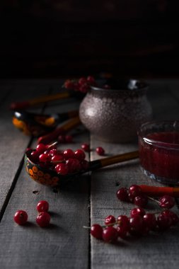 Kırmızı frenk üzümü ve geleneksel Rus boyalı ahşap kaşıklar.