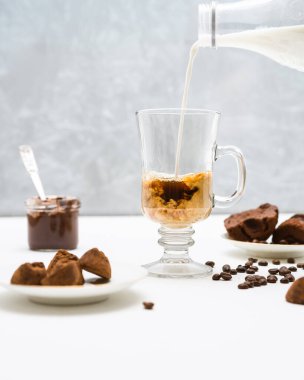 Sütü cam bir kahve bardağına döküyorum. 