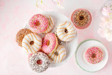 Pembe arka planda çeşitli jöleli çörekler.