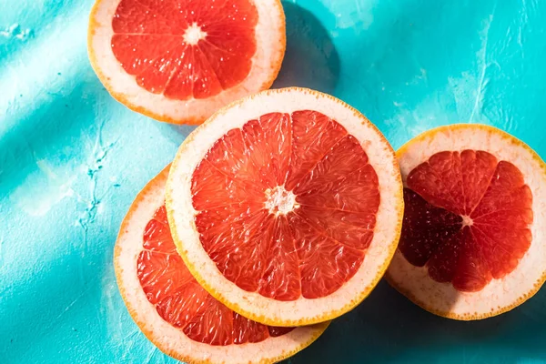 Fatias Toranja Vermelha Fundo Azul — Fotografia de Stock Grátis