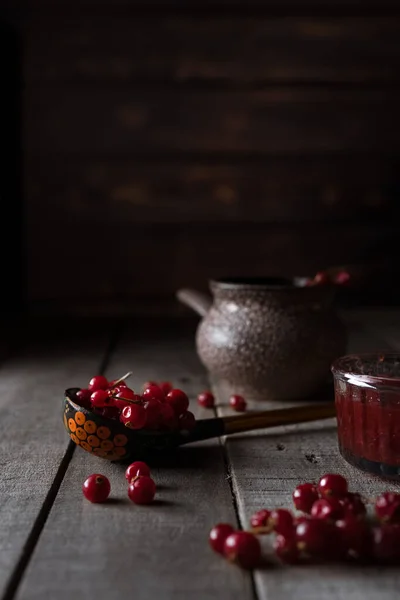 红色的红醋栗和传统的俄罗斯彩绘木勺的乡村背景 — 图库照片