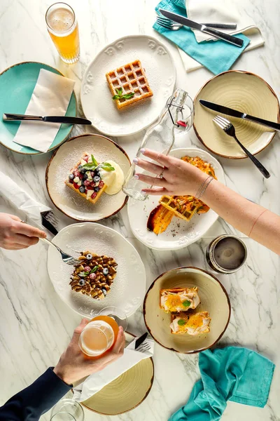 Pemandangan bagus dari orang yang makan wafel Belgia dan minum bir — Stok Foto