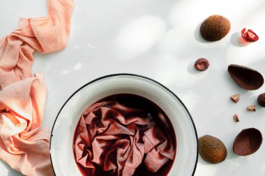 Pembe kumaş, avokado kabukları ve çukurlar, ıslak kumaşlı tencere, üst manzara.