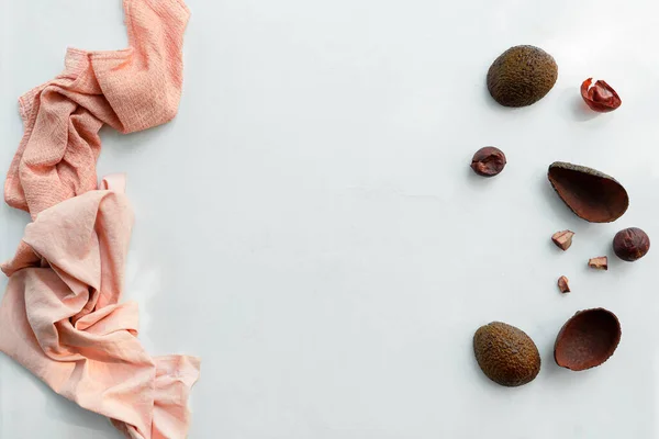 Avokado derisi ve çukurlarla boyanmış pembe renkli kumaş. Kopyalama alanı olan üst görünüm. Beyaz arkaplan