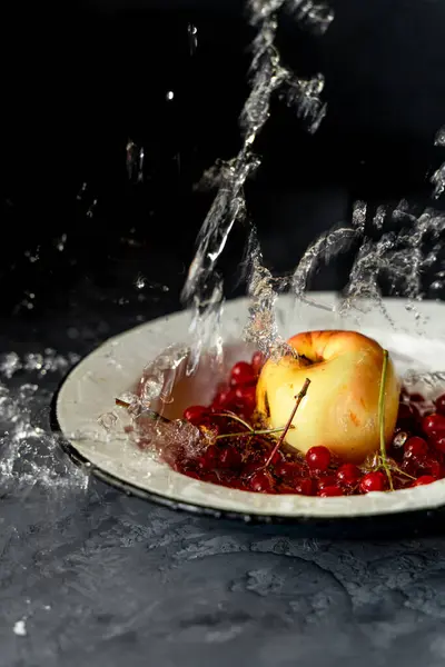 Gult Äpple Och Röda Bär Vit Tallrik Med Stänk Vatten — Stockfoto