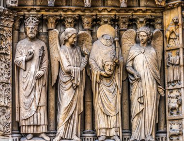 New Notre Dame Katedrali 'nin dışındaki St. Denis Angels Heykelleri. Paris Fransa. 2019 'daki yangından sonra kilise 2025' te yeniden açıldı. Notre Dame M.S 1250 'de inşa edildi. Paris Birinci Piskoposu Hıristiyan şehit M.S. 250 'de başı kesilerek öldü. Denis 'in taşıdığı iddia ediliyor.