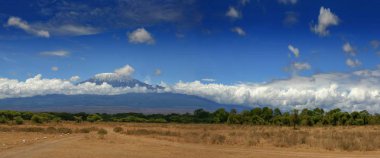 Kilimanjaro Dağı bulutlu mavi güneşli gökyüzü altında kepli Tanzanya kar sus Afrika Kenya'da safariye ele geçirdi. Karlı dağ Afrika manzara dağcılar rüya gelmek doğru.