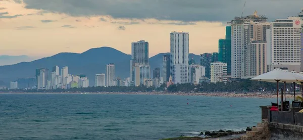 Nha Trang, Vietnam, Asya 6 Haziran 2018. Vietnamca gökdelen otel ve apartman blokları ile resort beach açık manzarası manzara tatil. Arka planda engebeli dağ manzarası ile Güney Çin Denizi üzerinde.