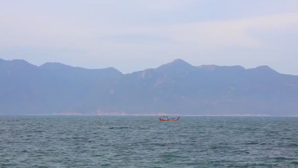 南中国海和一艘小船在越南中部与山背景 热带亚洲景观与绿松石海洋的景色 — 图库视频影像