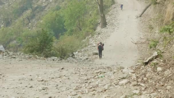 Portavalige con gli zaini pesanti sul circuito di montagna di Manaslu Trek in Nepal . — Video Stock