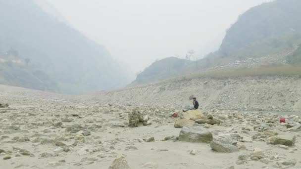 Nepalesischer Führer ruht sich auf dem Stein aus. Manaslu Circuit Trek. — Stockvideo