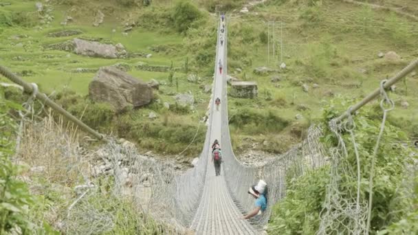 Backpackers Nepal Nehri üzerinde asma köprü üzerinde yürümek. Manaslu devre trek. — Stok video