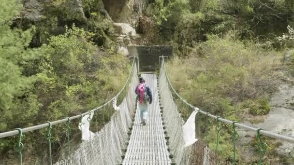 Local nepalese person walk on suspension bridge. Manaslu circuit trek area. — Stock Video