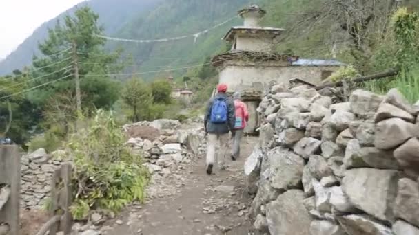 Turistas caminando en la aldea nepalesa Prok, caminata alrededor de la montaña Manaslu, Nepal . — Vídeos de Stock