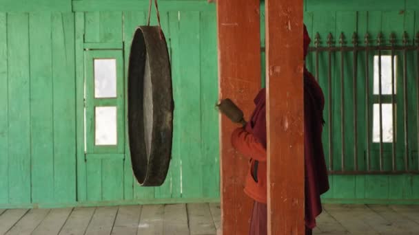 Jonge monnik verslaat in grote gong in nepalese dorpje Lho, Nepal. — Stockvideo