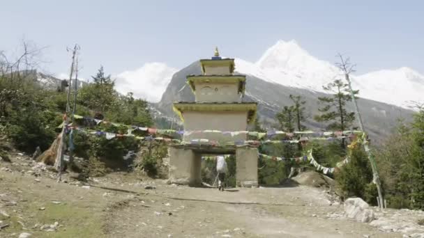 Tourist leaves the village through the arch on trekking in Himalaya, Nepal. — Stock Video