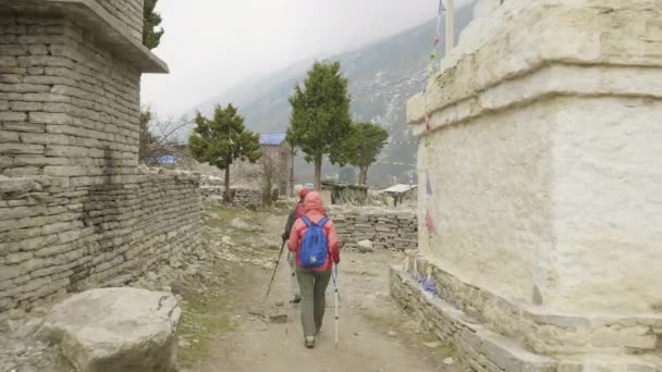 Séta a nepáli faluban hátizsákos. Manaslu circuit trek terület. — Stock videók