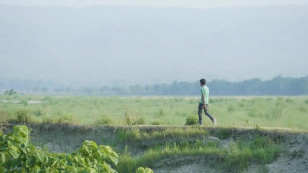 Giovanotto che cammina lungo il fiume nel parco nazionale. Frontiera Nepal-India . — Video Stock