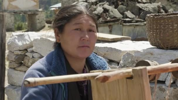 SHYALA, NEPAL - MARÇO, 2018: Mulher local trança manualmente o tapete em um tear caseiro antigo . — Vídeo de Stock