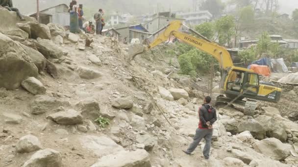 MANASLU, NEPAL - MARCH, 2018: Excavator repairs a stone road in the mountains. — Stock Footage MANASLU, NEPAL - MARCH, 2018: Excavator repairs a stone road in the mountains. Royalty Free Stock Footage