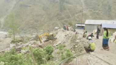 Manaslu, Nepal - Mart, 2018: Ekskavatör dağlarda taş bir yol onarır..