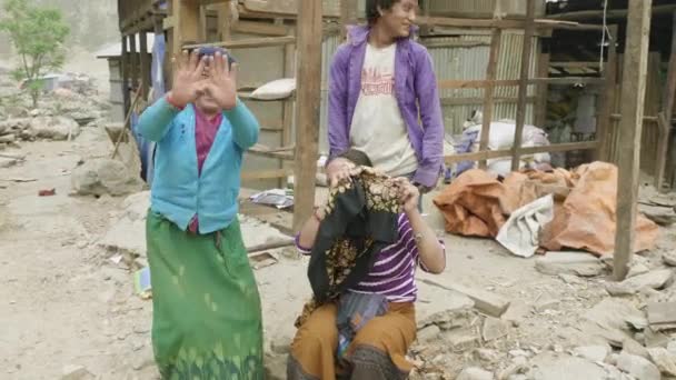 MANASLU, NEPAL - MARCH, 2018: Local people hide faces and smile in camera. — Stock Video