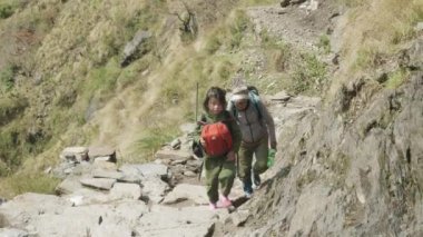 Manaslu, Nepal - Mart, 2018: Dağlar okulda dedesi ile yerel çocuk gitmek.