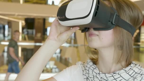 Любопытная изумленная женщина пробует очки дополненной реальности, взволнована симуляцией VR гарнитуры, исследует виртуальную жизнь жестом рук, чтобы прикоснуться к 3d миру, развлекаясь с очками . — стоковое видео