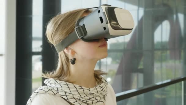 Curiosa mujer sorprendida probando gafas de realidad aumentada, sintiéndose emocionada con la simulación de auriculares VR, explorando la vida virtual haciendo gestos con las manos para tocar el mundo 3d, divirtiéndose con gafas . — Vídeo de stock