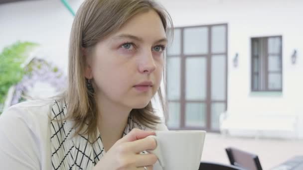 若い女の子の飲み物をコーヒーと見て. — ストック動画