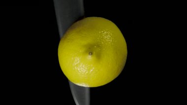 Siyah bir arka plan üzerinde stüdyoda bir bıçakla kesip Iolated limon