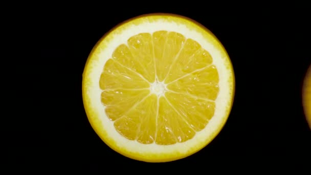 Ізольований апельсин, вирізаний ножем у студії на чорному тлі — стокове відео