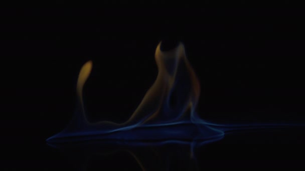 Flames burn on the mirror surface on a black background — Stock Video