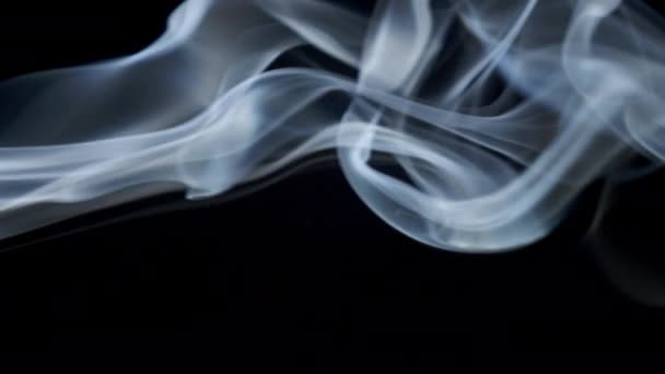 Ondas de humo azul blanco abstracto se mueve lentamente sobre el fondo negro — Vídeos de Stock