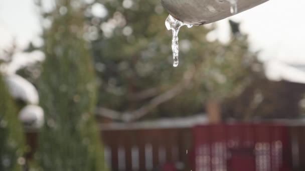 Víz folyik a jégcsapok, a tetőn, tavaszi idő — Stock videók