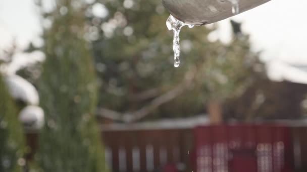 El agua fluye de los carámbanos en el techo, tiempo de primavera — Vídeo de stock