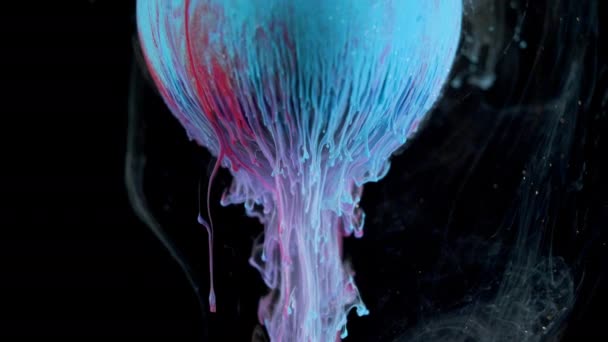 Різнокольорова чорнильна фарба повільно тече з м'яча — стокове відео