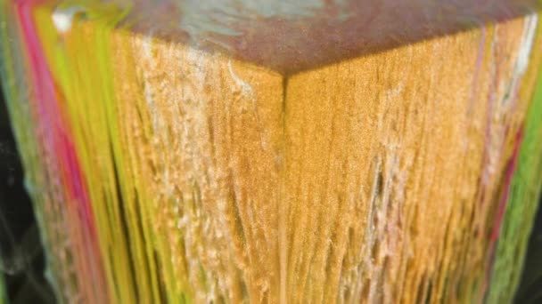 La peinture à l'encre multicolore coule lentement du cube sous l'eau 