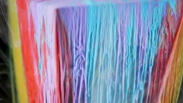 Bunte Tintenfarbe fließt langsam aus dem Würfel unter Wasser — Stockvideo