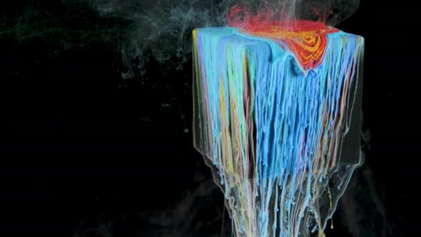 A tarka festék lassan átfolyik a víz alatti kockából — Stock videók
