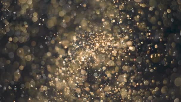 Flujo de partículas elegantes, detalladas y doradas con poca profundidad de campo bajo el agua — Vídeos de Stock