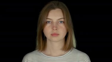 Siyah stüdyoda genç ciddi uzun saçlı beyaz kız yakın çekim portre